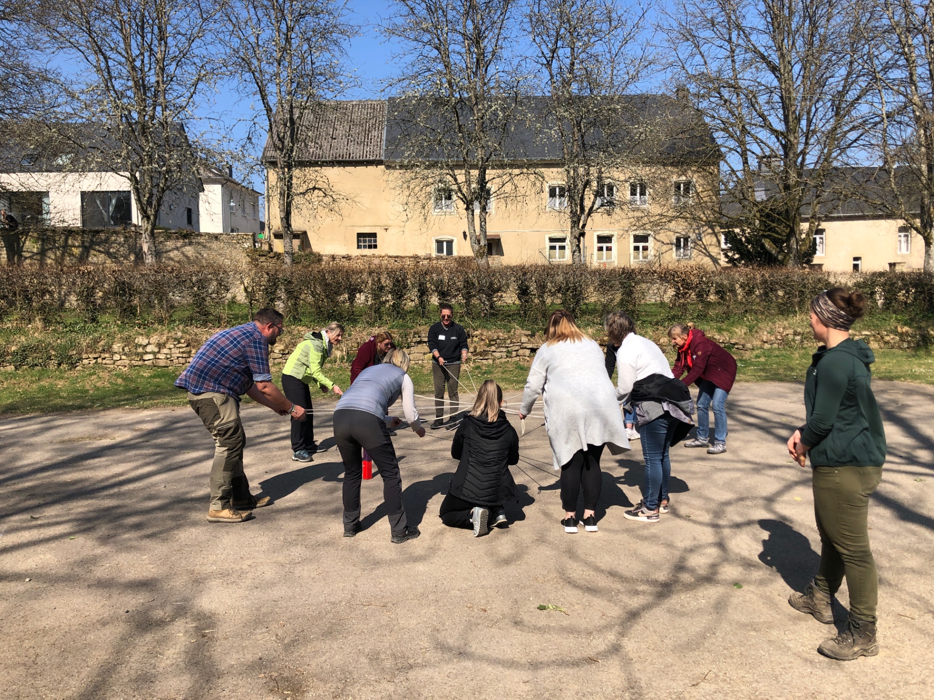 Gruppe bei einer Seil-Teamübung im Freien