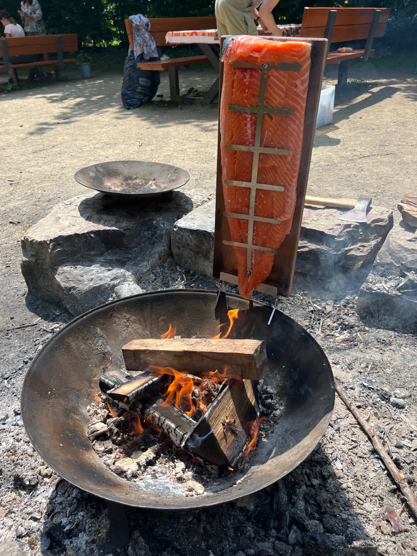 Lehmofen mit brennendem Feuer und Topf darauf