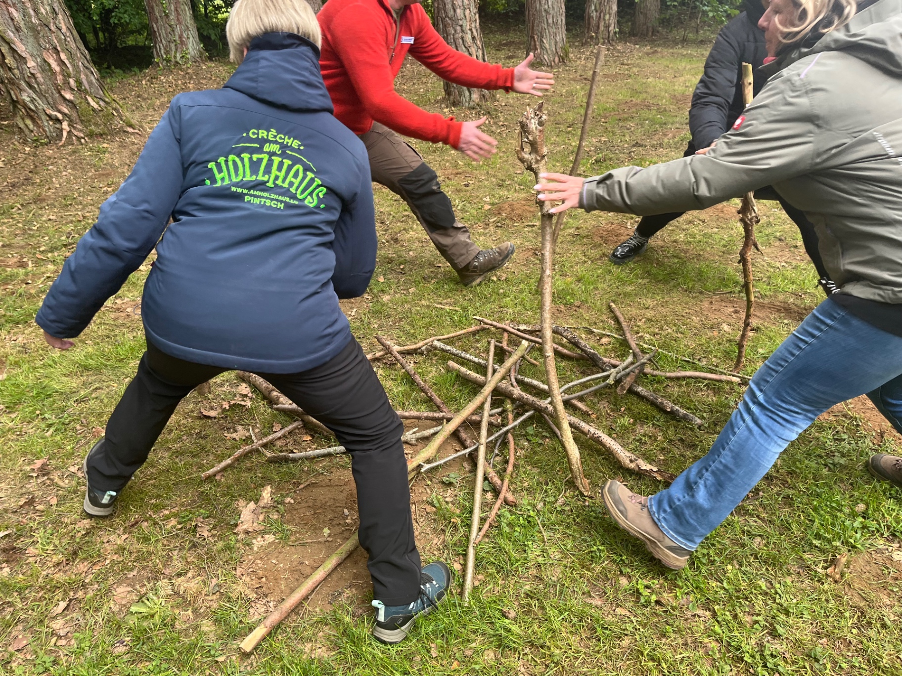 Team-Übung im Wald mit Ästen und Stöcken